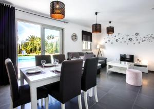 a dining room and living room with a table and chairs at Villa Vallesa Calpe in Ifach