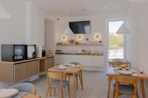 a dining room with a table and chairs and a kitchen at Villa Miki in Podstrana