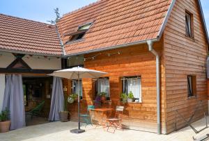 a wooden house with a table and chairs and an umbrella at L'Atelier des dépendances in Lipsheim