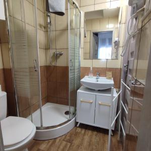 uma casa de banho com um chuveiro, um WC e um lavatório. em Rybaki 6A em Poznań