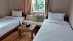 Un pat sau paturi într-o cameră la Hotel Blossom