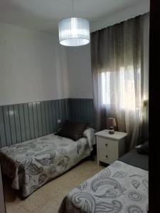 ein Schlafzimmer mit zwei Betten und einem Kronleuchter in der Unterkunft Casa Manoli in El Palmar