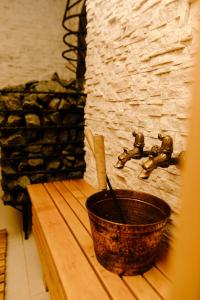 a bucket sitting on a wooden table next to a stone wall at Green Town in Vievis