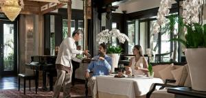 a man giving a man a plate of food in a restaurant at InterContinental Bali Resort by IHG in Jimbaran