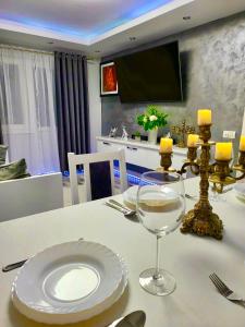 einen Tisch mit einer weißen Platte und einem Weinglas in der Unterkunft Studio DeLux in Giurgiu