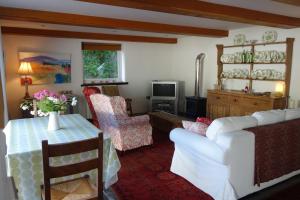 a living room with a couch and a table and chairs at St Michaels Coach House in Crediton