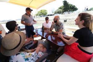 Private yacht, we love our guests في لشبونة: مجموعة من الناس يجلسون حول طاولة على متن قارب
