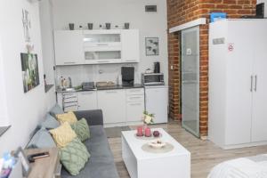 a living room with a couch and a kitchen at Helly's apartman - self check-in - in Jajce