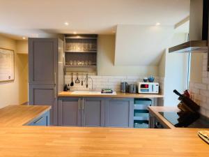 a kitchen with blue cabinets and a counter top at Stalker's Cottage in Spean Bridge