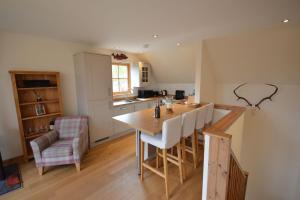 a kitchen with a table and chairs in a room at Tall Pines Apartment in Spean Bridge