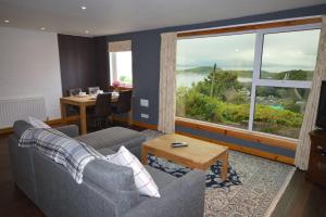 a living room with a couch and a table and a window at Ardura Apartment No 1 in Oban
