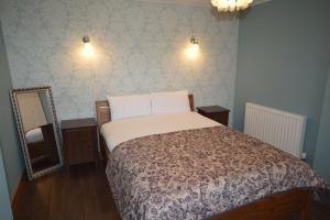 Un dormitorio con una cama grande y un espejo. en Ardura Apartment No 2, en Oban