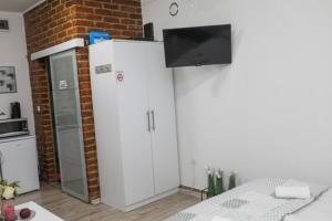 a room with two white refrigerators and a brick wall at Helly's apartman - self check-in - in Jajce