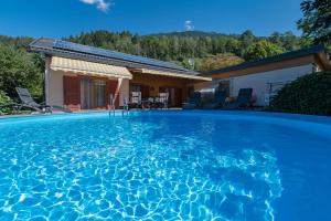 a swimming pool in front of a house at Ferienwohnungen Angermaier in Flattach