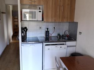 a small kitchen with white appliances and a microwave at Appartement Valloire, 2 pièces, 5 personnes - FR-1-263-164 in Valloire