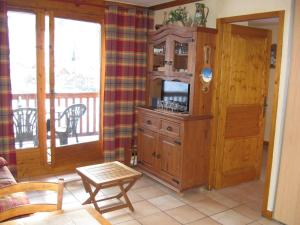 a living room with a wooden cabinet and a balcony at Appartement Valloire, 2 pièces, 4 personnes - FR-1-263-128 in Valloire