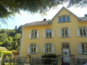 ein gelbes Haus mit weißen Fensterläden drauf in der Unterkunft LES LILAS in Sainte-Marie-aux-Mines