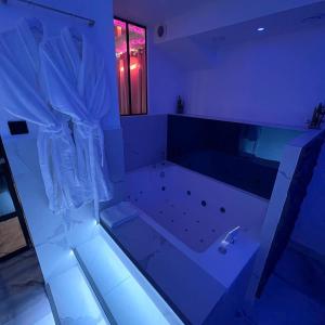a large bathroom with a tub with blue lighting at Le BLUE in Aubervilliers