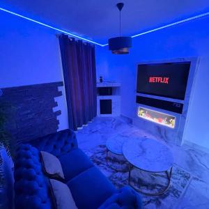 sala de estar con sofá y chimenea en Le BLUE, en Aubervilliers