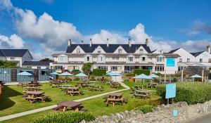 a large hotel with tables and chairs in front of it at Trearddur Bay Hotel in Trearddur