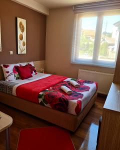 a bedroom with a large bed with red sheets and pillows at Hotel Bulevar in Bitola