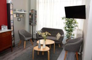 a living room with a couch and two chairs and a table at Hotel Joly in Armentières