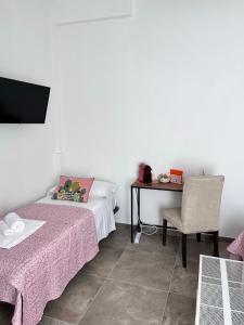 ボローニャにあるCapoDiLucca40のベッド、テーブル、椅子が備わる客室です。