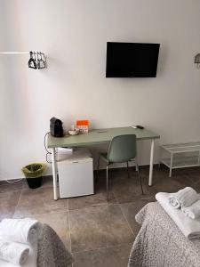 a desk with a chair and a television on a wall at CapoDiLucca40 in Bologna +19 photos
