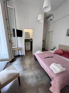 a bedroom with a pink bed and a couch at CapoDiLucca40 in Bologna