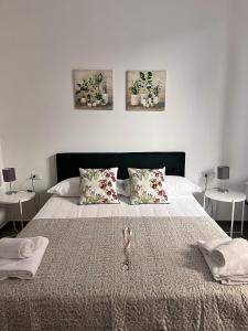 a white bedroom with a large bed with two tables at CapoDiLucca40 in Bologna