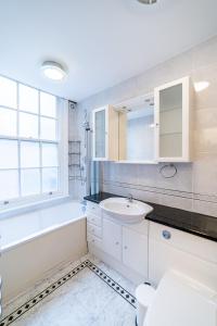 een badkamer met een wastafel, een bad en een toilet bij (St' Paul Cathedral) London Studio Apartment in Londen