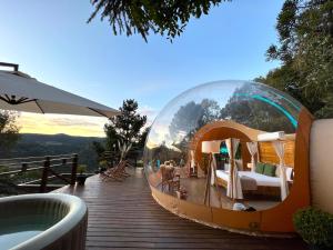 a glass dome hotel with a bed and a tub at Zion Bubble Glamping in Urubici