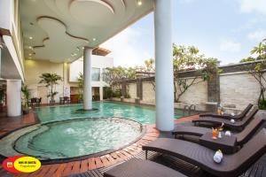 a swimming pool in the middle of a house at Ros-In Hotel in Yogyakarta