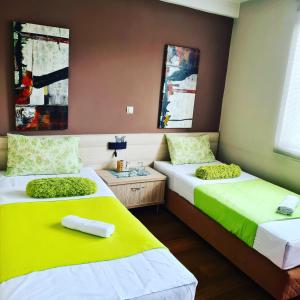 two beds in a room with yellow and white at Hotel Bulevar in Bitola