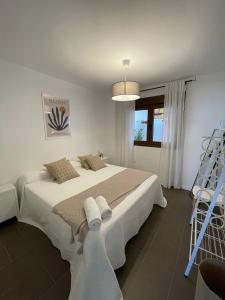 um quarto branco com uma cama grande e lençóis brancos em Coello 31 em Jaén