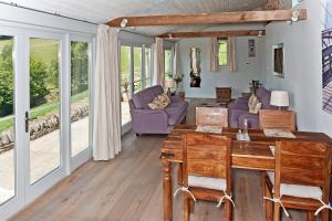 sala de estar con mesa y sillas en Valley Barn Slad Valley Cotswolds, en Painswick