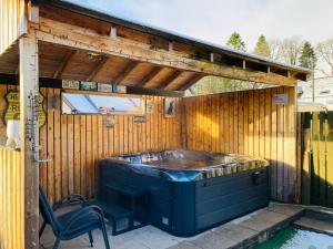a hot tub in a backyard with a wooden wall at Aonachan Cottage in Spean Bridge