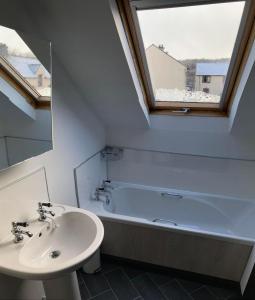 a bathroom with a sink and a bath tub at Aonachan Cottage in Spean Bridge