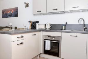 una cocina con armarios blancos y fregadero en Charmant Studio tout confort au Brévent-Chamonix en Chamonix-Mont-Blanc