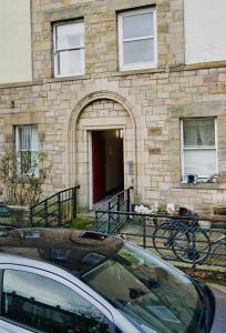 a car parked in front of a building with a red door at SIMPLE 2BED FLAT IN EDINBURGH. in Edinburgh