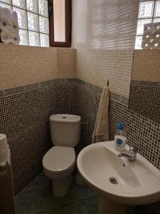 a bathroom with a toilet and a sink at Vivienda compartida con ambiente familiar in Seseña
