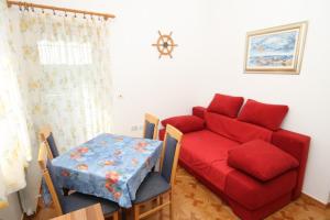 a living room with a red couch and a table at Apartments and rooms with a swimming pool Babici, Umag - 3046 in Umag