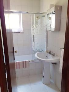 a bathroom with a sink and a shower at Baleal Sol Alojamentos in Baleal +40 photos