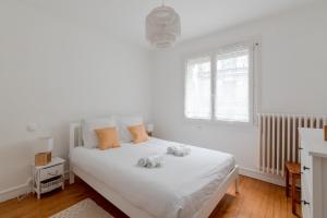 1 dormitorio con 1 cama blanca y 2 toallas en Appartement lumineux centre de Saint-Nazaire en Saint-Nazaire