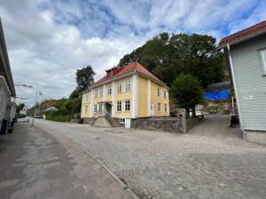 une maison jaune sur le côté d'une rue dans l'établissement Fint, gratis parkering, med 20 min till Göteborg C, à Kungälv