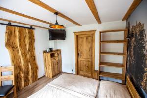 a bedroom with a bed and a tv on the wall at Folwark Wierzchy in Wierzchy