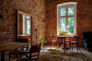 a room with a table and chairs and a brick wall at Folwark Wierzchy in Wierzchy