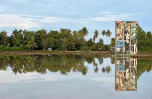 a reflection of a building in a body of water at Homestay D'Art Container in Balik Pulau