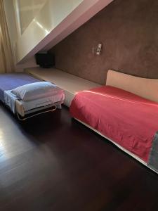 sypialnia z 2 łóżkami z czerwoną pościelą w obiekcie Attico centro storico w mieście Pawia