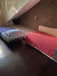 a bedroom with two beds with red sheets at Attico centro storico in Pavia
